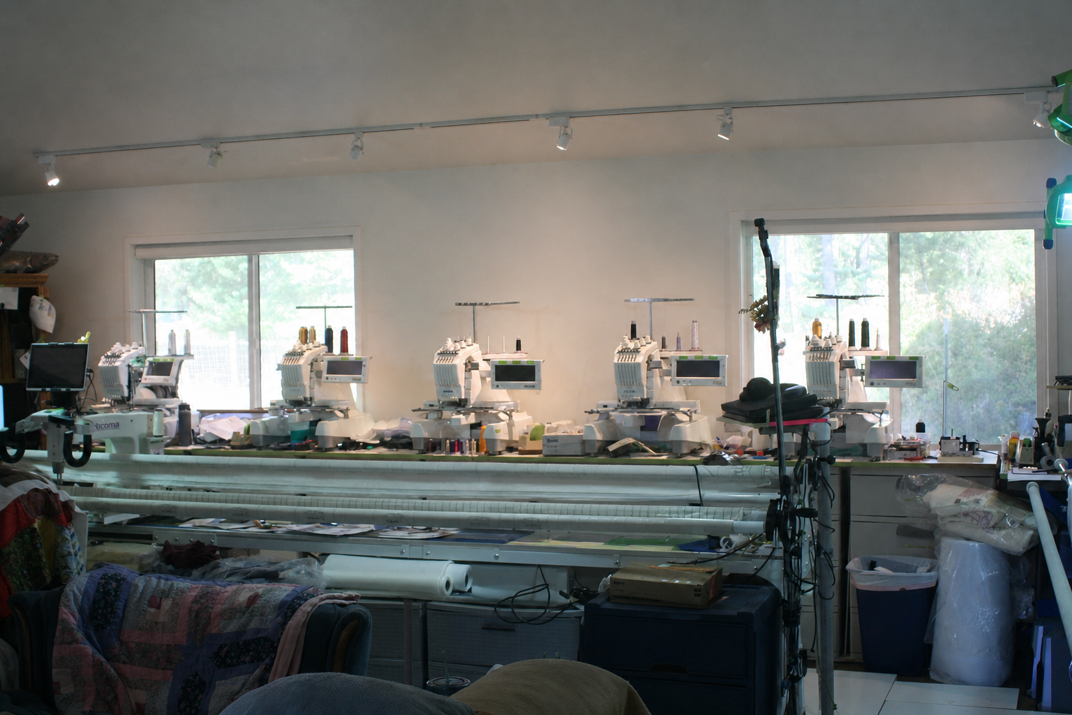 Claude's embroidery machines and longarm quilting equipment in the We Bee Quiltin' workshop